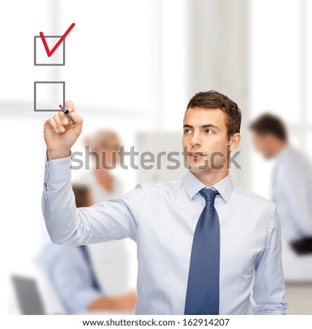 Business And Office Concept - Attractive Buisnessman Or Teacher With Marker Drawning Red Checkmark Into Checkbox