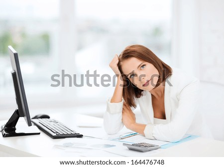 business, education and technology concept - stressed businesswoman with computer, papers and calculator in office