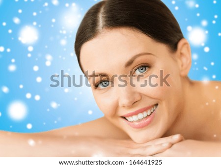 health and beauty, resort and relaxation concept - beautiful smiling woman in spa salon lying on the massage desk