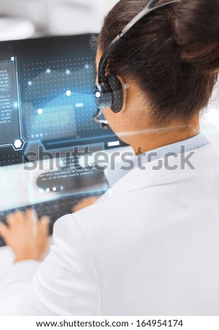 business, communication and call center concept - friendly female helpline operator with headphones and computer