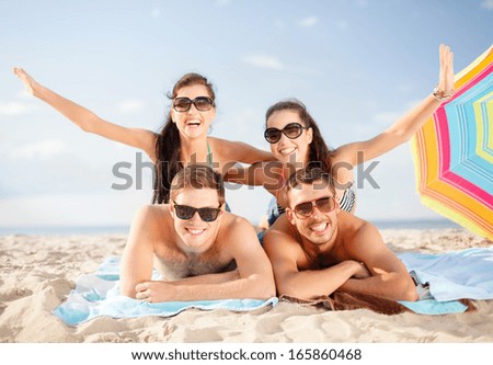 summer, holidays, vacation and happy people concept - group of smiling people in sunglasses having fun on the beach