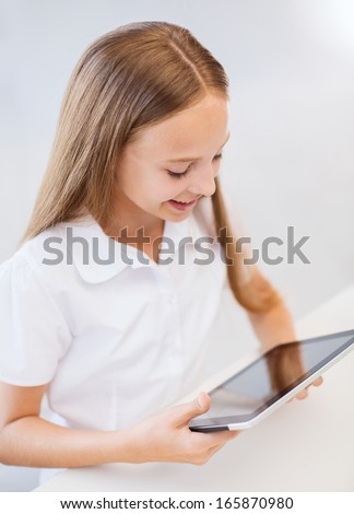 education, school, technology and internet concept - smiling little student girl with tablet pc computer at school