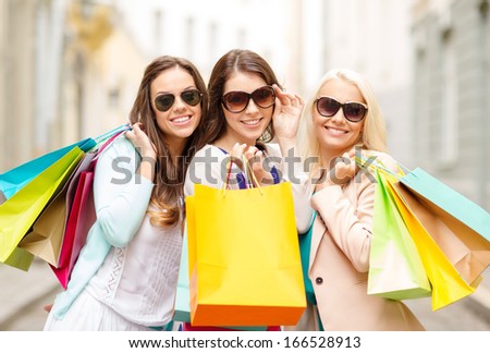 Shopping, Sale, Happy People And Tourism Concept - Three Beautiful Girls In Sunglasses With Shopping Bags In Ctiy
