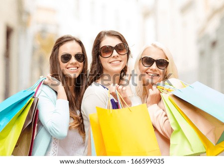 Shopping, Sale, Happy People And Tourism Concept - Three Beautiful Girls In Sunglasses With Shopping Bags In Ctiy