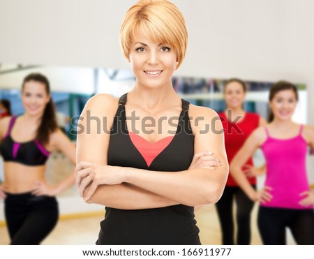 fitness, sport, training, gym and lifestyle concept - group of smiling women with trainer exercising in the gym