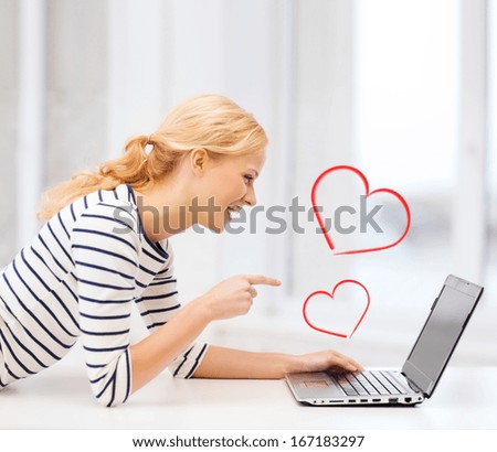 Love And Internet Concept - Smiling Student Girl Pointing Her Finger At Laptop Screen In College