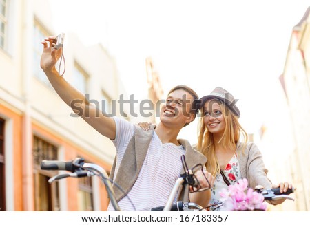 summer holidays, travel, vacation, tourism and dating concept - traveling couple with bicycles taking selfie with digital camera