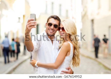 Summer Holidays, Technology, Love, Relationship And Dating Concept - Smiling Couple Taking Picture With Smartphone In The City