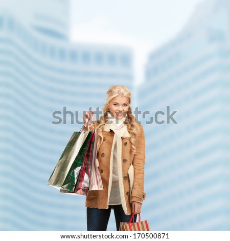 shopping and sale concept - lovely woman with shopping bags outdoors