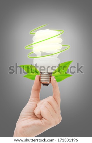 electricity and energy concept - close up of woman hand holding energy efficient light bulb