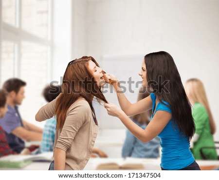 bullying, school, education, friendship and people concept - two teenagers having a fight and getting physical