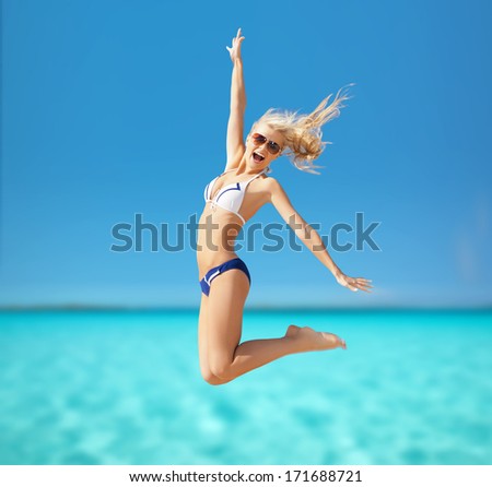 summer holidays, vacation and lingerie concept - happy woman jumping on the beach