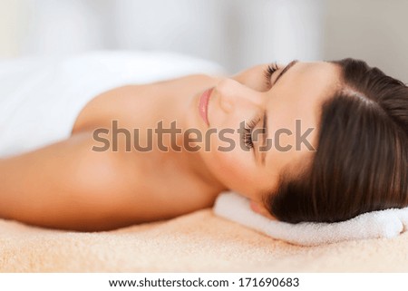 Beauty And Spa Concept - Beautiful Woman In Spa Salon Lying On The Massage Desk