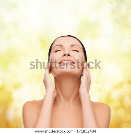 health, spa and beauty concept - clean face and hands of beautiful smiling woman with closed eyes
