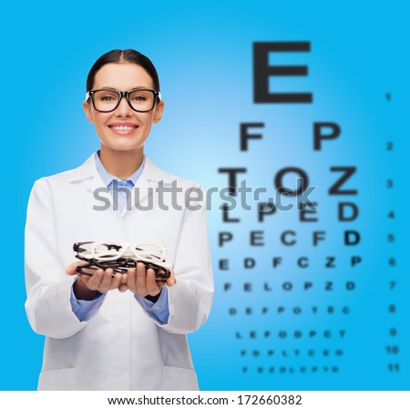 healthcare, vision and medicine concept - smiling female doctor with many eyeglasses and eye chart