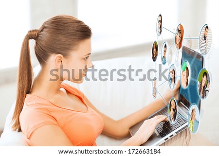 lifestyle, social networking and internet concept - woman using laptop at home