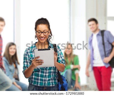 education, technology and people concept - smiling female african american student in eyeglasses with tablet pc and bag
