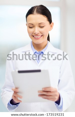 healthcare, technology and medicine concept - smiling young doctor with tablet pc computer in cabinet