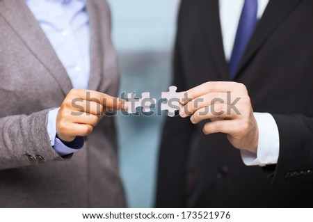 Business And Office Concept - Businessman And Businesswoman Trying To Connect Puzzle Pieces In Office