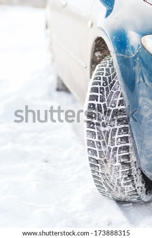 transportation, winter and vehicle concept - closeup of car winter tire