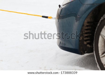 transportation, winter and vehicle concept - closeup of towed car with towing rope