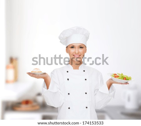 Cooking And Food Concept - Smiling Female Chef, Cook Or Baker With Salad And Cake On Plates