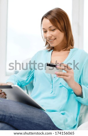 technology, banking, money, internet and home concept - smiling woman with tablet pc computer and credit card at home