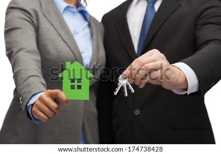 business, eco and real estate concept - businessman and businesswoman holding green house and keys