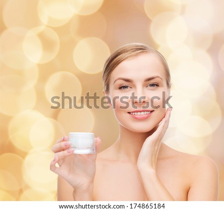 Cosmetics, Health And Beauty Concept - Beautiful Woman Applying Cream On Her Skin