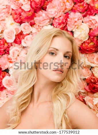 beauty and spa concept - face of beautiful woman and background full of roses