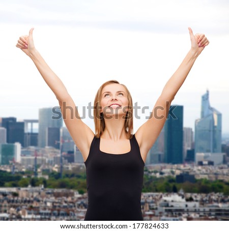 t-shirt design, happy people concept - smiling woman in blank black tank top showing thumbs up