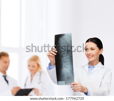 healthcare, medicine and radiology concept - smiling female doctor looking at x-ray
