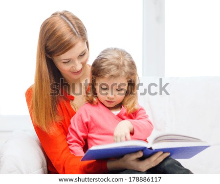 family, children, pre-school and happy people concept - happy mother and daughter with book