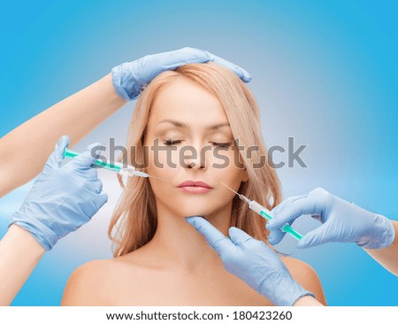 beauty and cosmetic surgery concept - woman with closed eyes and beautician hands with syringes