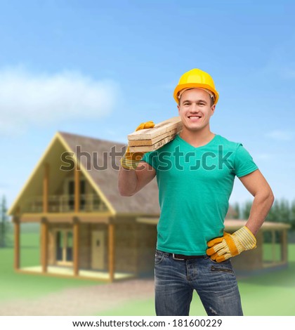 repair, construction and maintenance concept - smiling male manual worker in protective helmet carrying wooden boards outside the house