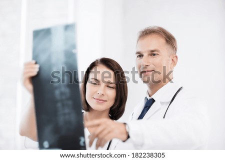 healthcare, medical and radiology concept - two doctors looking at x-ray