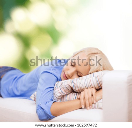 sleep and happiness concept - smiling young woman lying on sofa