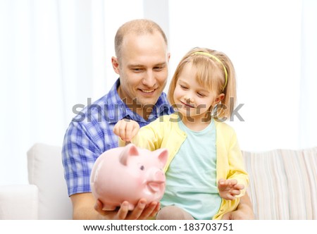 family, children, money, investmen and happy people concept - happy father and daughter with big pink piggy bank