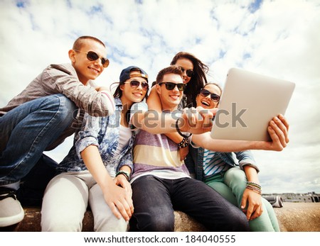 summer holidays, teenage and technology concept - group of teenagers taking picture with tablet pc