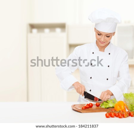 cooking and food concept - smiling female chef, cook or baker chopping vegetables