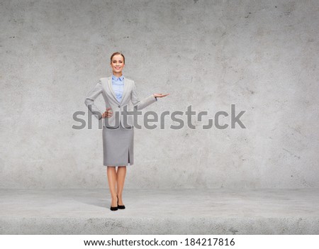 business and advertisement concept - smiling businesswoman showing something on palm of her hand