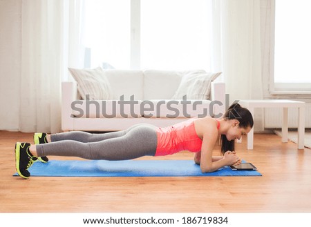 fitness, home and diet concept - smiling redhead teenage girl doing plank at home