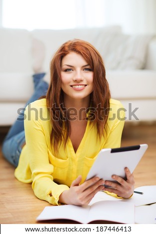 business, education and technology concept - smiling female student with notebooks and tablet pc computer at home