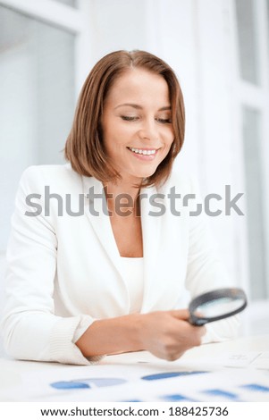 business, education, school, documents, people concept - smiling businesswoman or student working with graphs in office