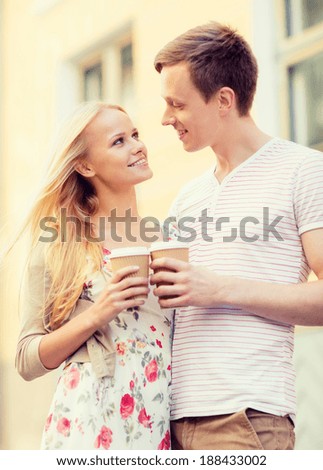 summer holidays, love, travel, tourism, relationship and dating concept - romantic couple in the city with takeaway coffee cups