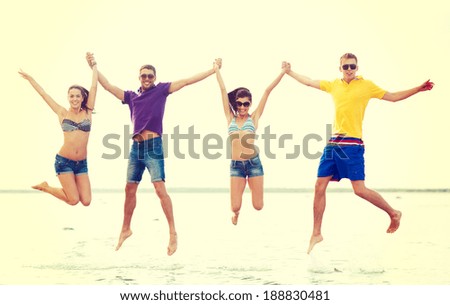 summer, holidays, vacation, happy people concept - group of friends or couples jumping on the beach