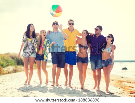 summer, holidays, vacation, happy people concept - group of friends having fun with ball on the beach