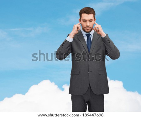 business concept - annoyed businessman covering ears with his hands