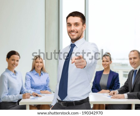 business, gesture and office concept - handsome businessman pointing finger at you