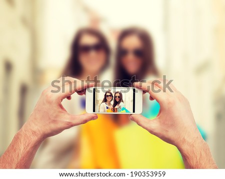 holidays, electronics and tourism concept - close up of man hands taking picture with smartphone camera
